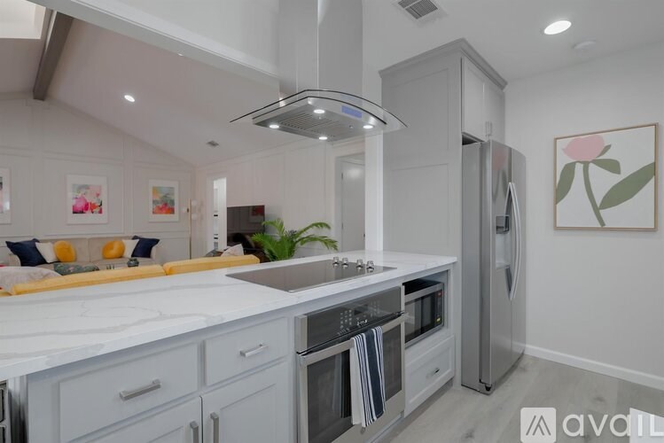 A modern kitchen with a refrigerator, oven, and sink.