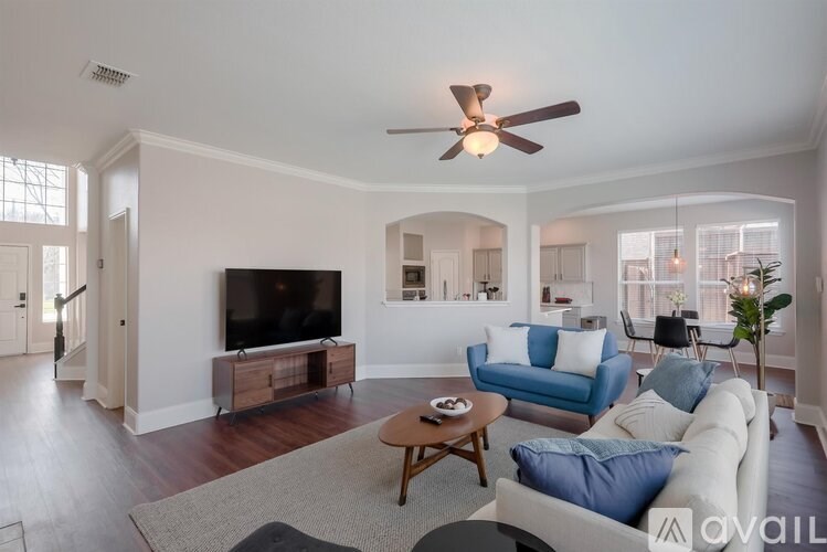 A living room with a television, a sofa, and a coffee table.
