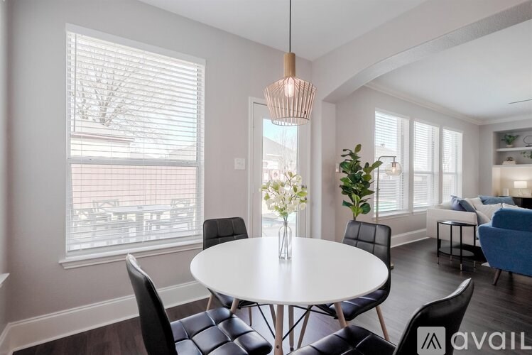 A modern dining room with a white table and chairs.