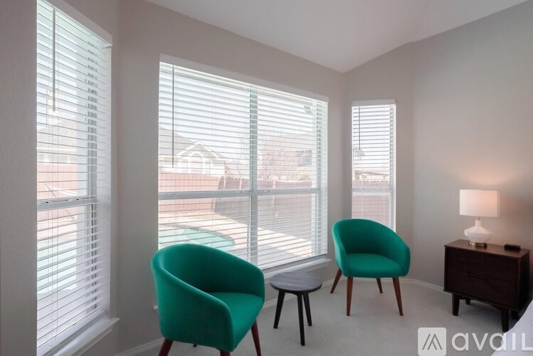 A room with two chairs and a table with a lamp on it.