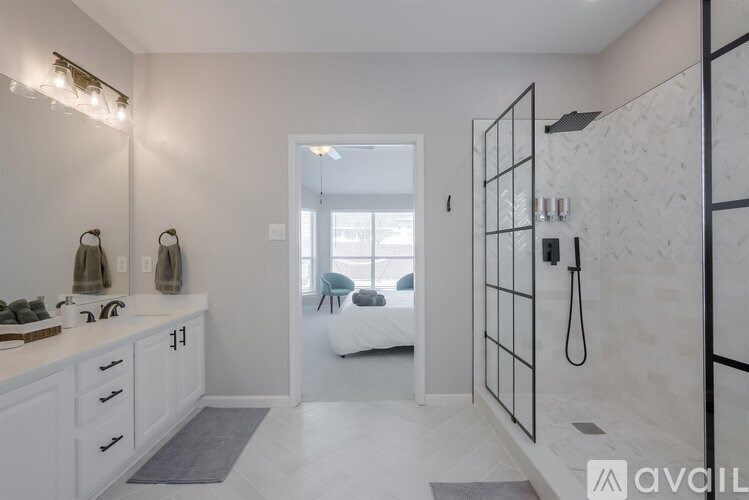 A bathroom with a walk-in shower and a vanity with a mirror.