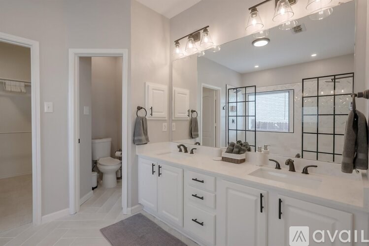 A bathroom with a white vanity and a large mirror.