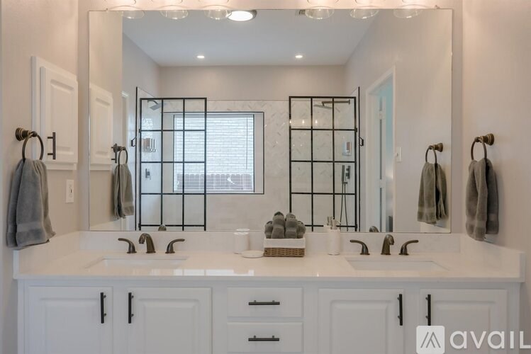 A bathroom with two sinks and a large mirror.