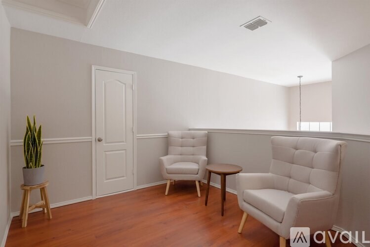 A room with a chair, a table, and a plant.