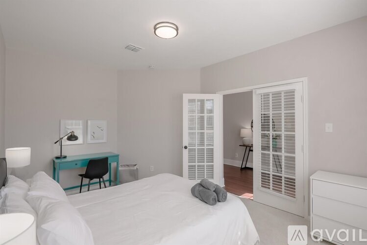 A bedroom with a bed, desk, and chair.