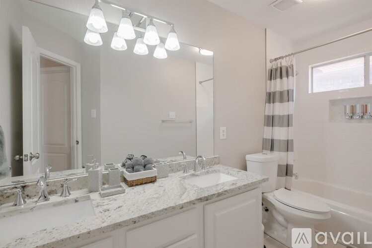 A bathroom with a marble countertop and a large mirror above it.
