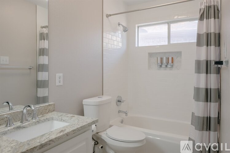 A bathroom with a toilet, sink, and shower.