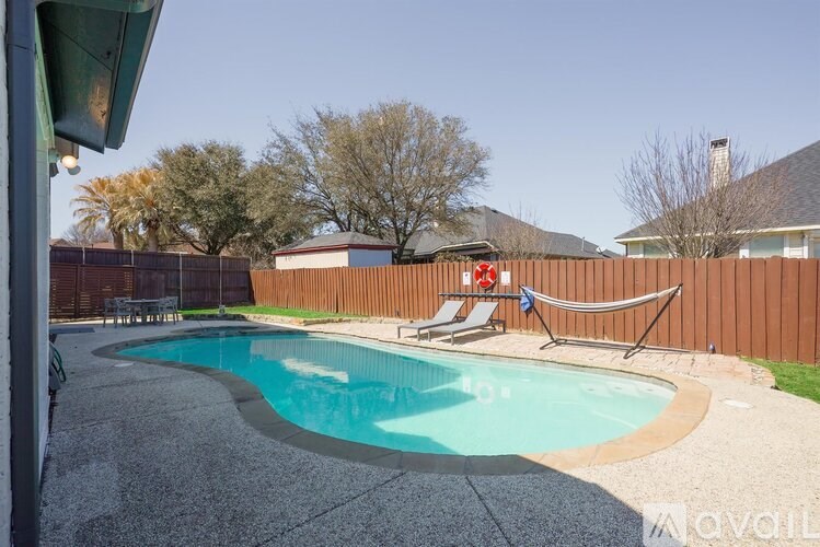 A backyard with a pool and a hammock.