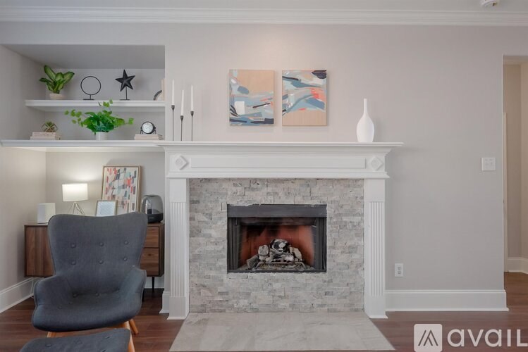 A living room with a fireplace and a grey chair.