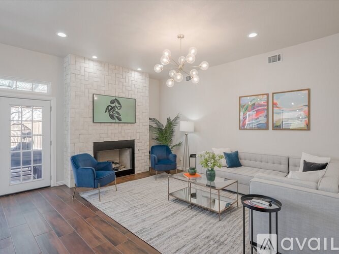 A living room with a fireplace and a blue chair.