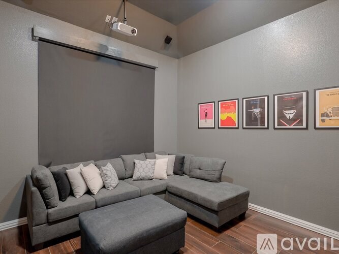 A living room with a grey couch and a grey ottoman.