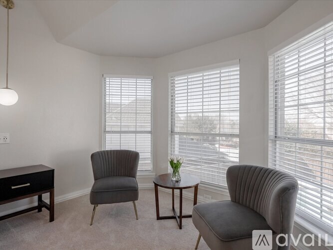 A living room with two chairs and a table.