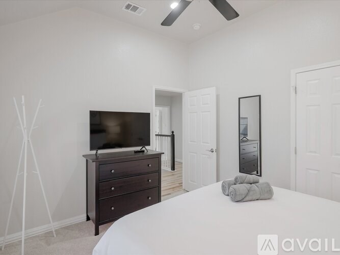 A bedroom with a bed, dresser, and mirror.