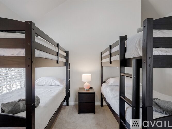 A room with two bunk beds and a nightstand in between.