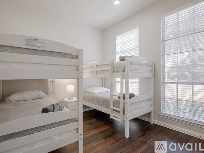 A white bunk bed with a single bed on top and a twin bed underneath.