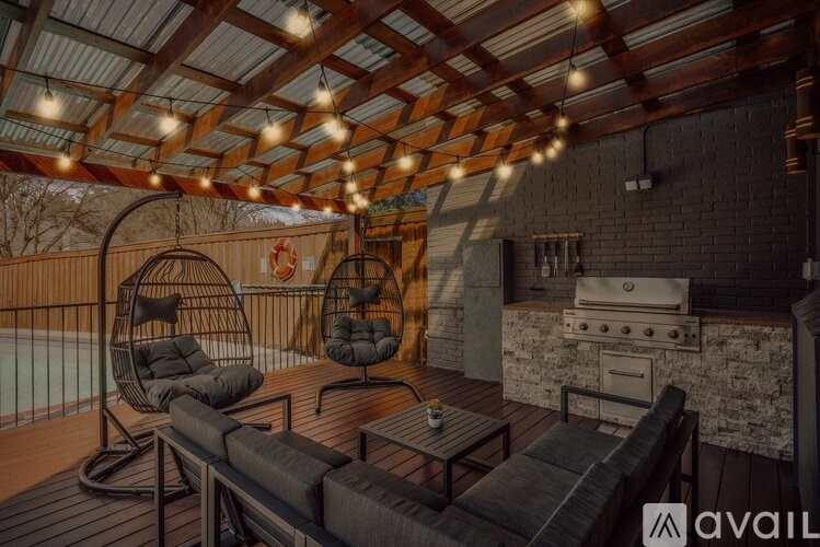 A patio with a grill and chairs.