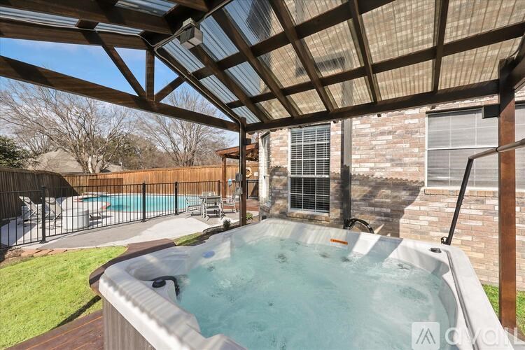 A hot tub is in the middle of a wooden deck.