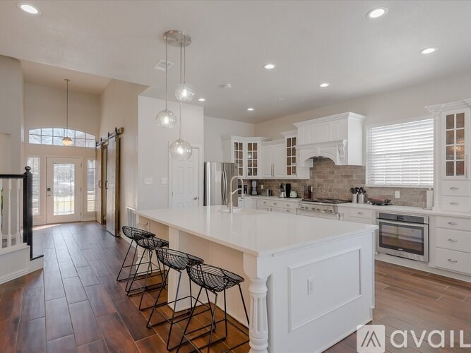 A modern kitchen with white cabinets and a central island.