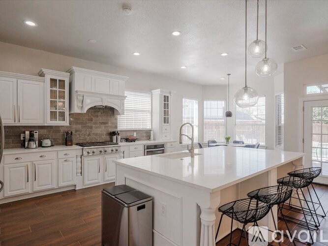 A kitchen with white cabinets and a large island.