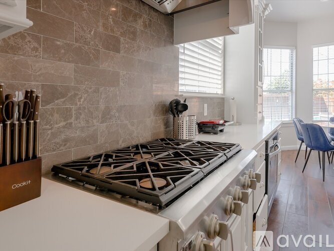 A modern kitchen with a white countertop and a stove with a black grate.
