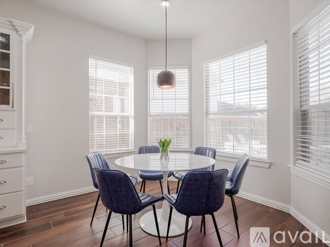 A dining room with a round table and chairs.
