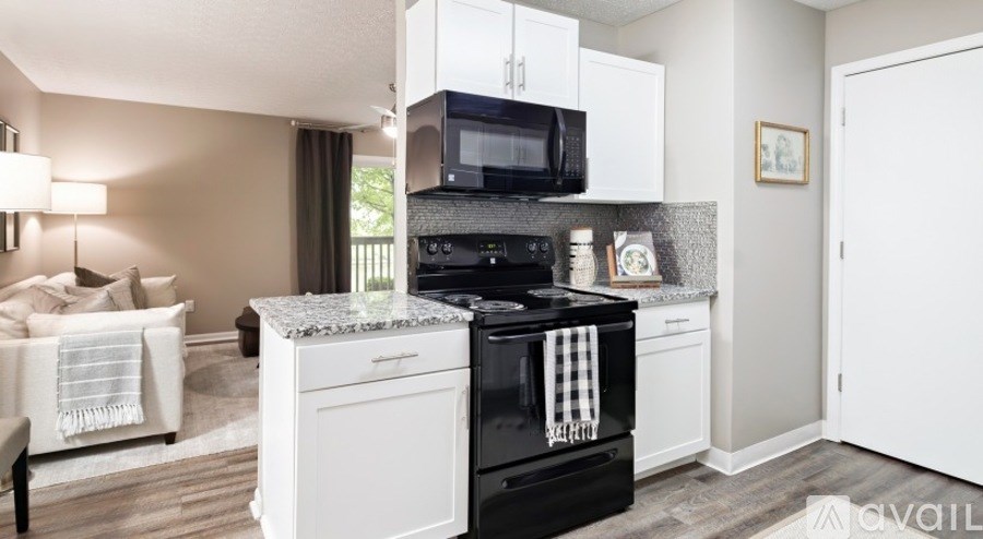 A modern kitchen with a black oven and white cabinets.