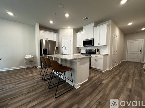 A kitchen with white cabinets and a wooden floor.