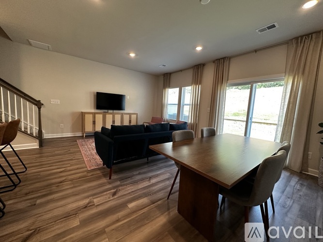 A living room with a couch, a television, and a dining table.