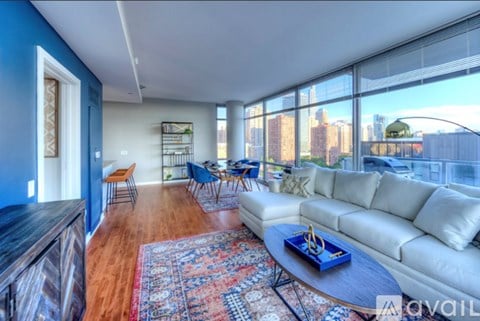 A living room with a white sofa and a coffee table in front of a large window.