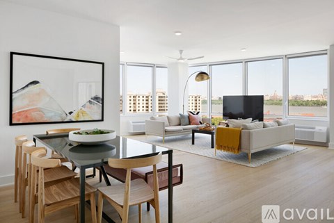 A modern living room with a glass table and chairs, a sofa, and a television.