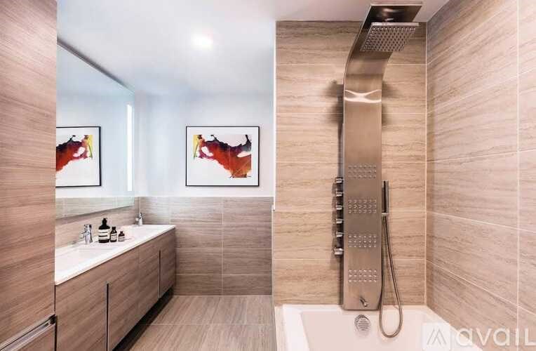 A modern bathroom with a walk-in shower and a vanity.