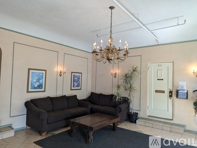A living room with a chandelier, two couches, and a coffee table.