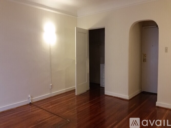 A room with wooden floors and a light on the left side.