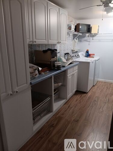 A kitchen with white cabinets and a wooden floor.