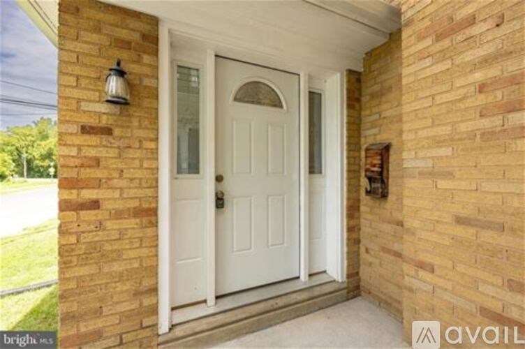 A white door is on a brick house.