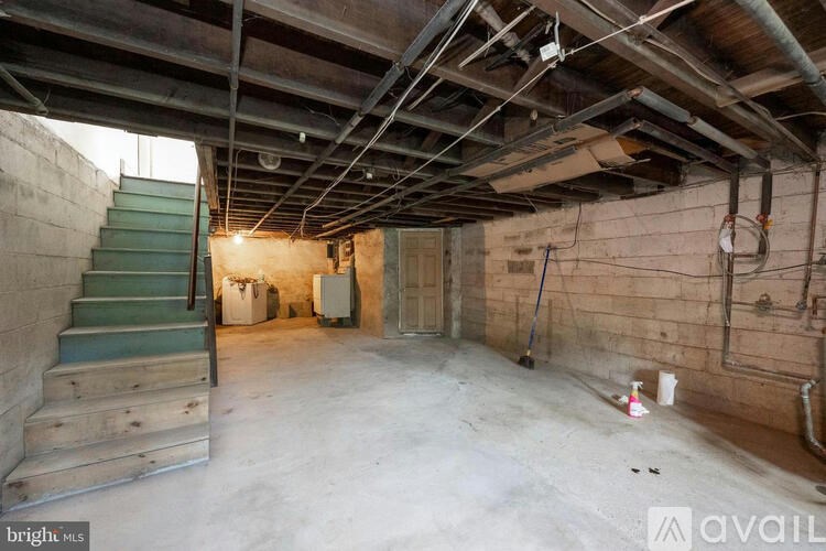 A large, empty room with a staircase on the left side.