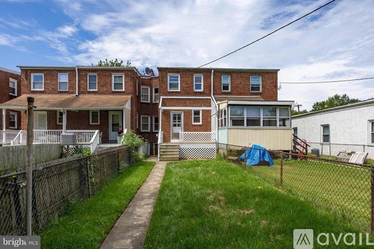 A brick house with a blue tarp on the lawn.