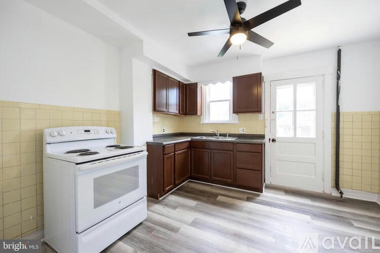 A kitchen with a white stove and wooden cabinets.