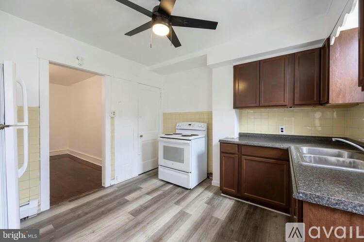 A kitchen with a refrigerator, oven, and sink.