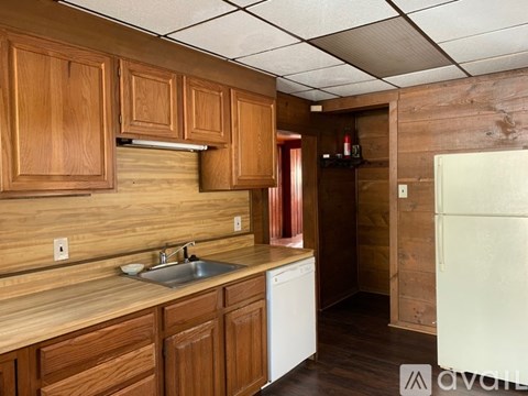 A kitchen with wooden cabinets and a white dishwasher.