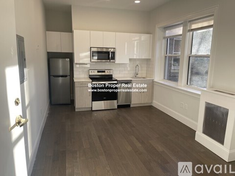 A kitchen with a refrigerator, microwave, and oven.