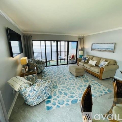 A living room with a couch, chair, and a patterned rug.