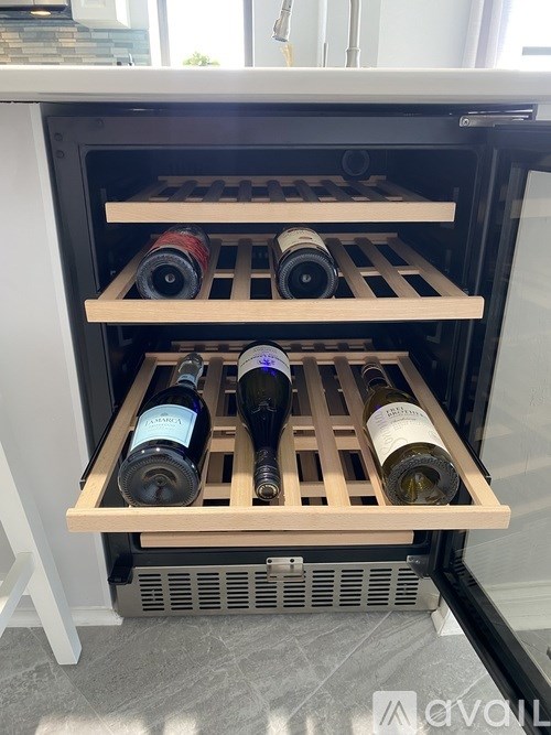 A wine rack with several bottles of wine on a kitchen counter.