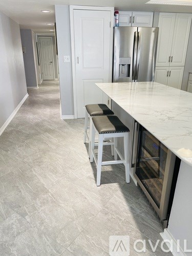 A kitchen with a white counter and a refrigerator.