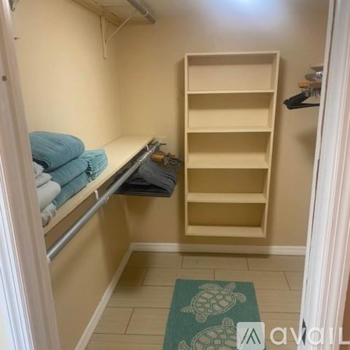 A small room with a shelf and towels.