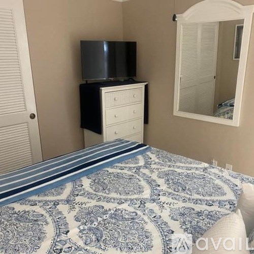 A bedroom with a bed, dresser, and mirror.