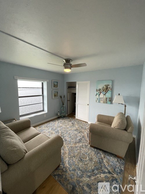 A living room with a beige couch and a rug.