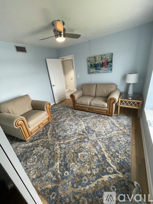 A living room with a rug and two couches.