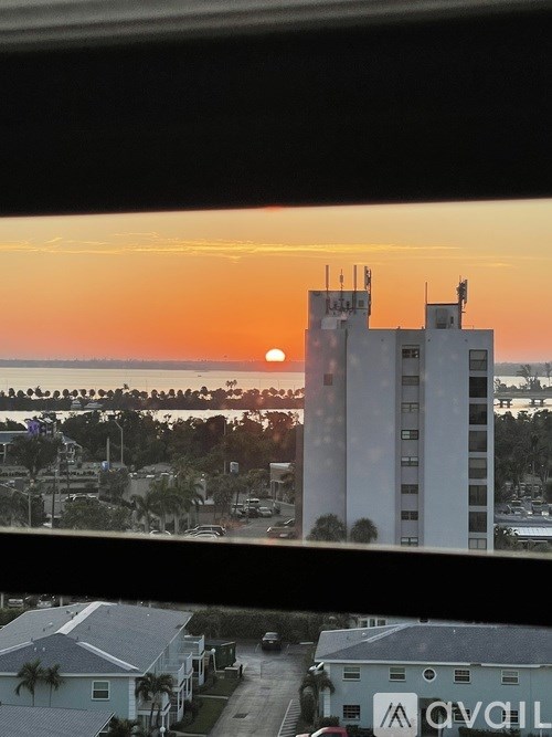 A sunset view from a window overlooking a residential area.