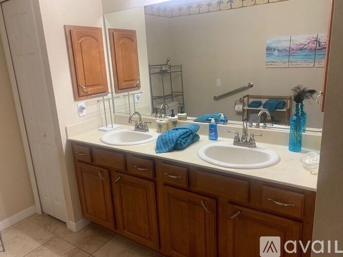 A bathroom with two sinks and wooden cabinets.